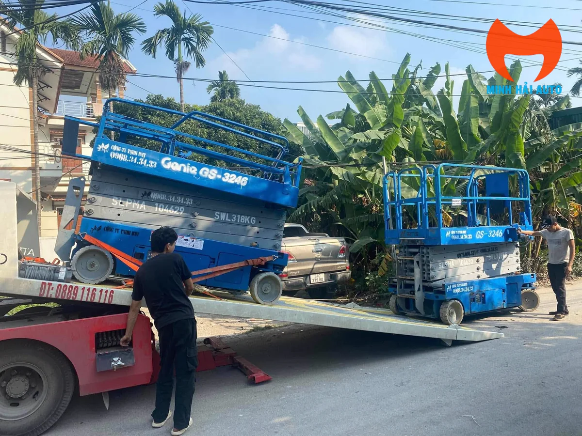 Xe nâng người cắt kéo điện được đưa xuống theo cầu dẫn của xe vận chuyển