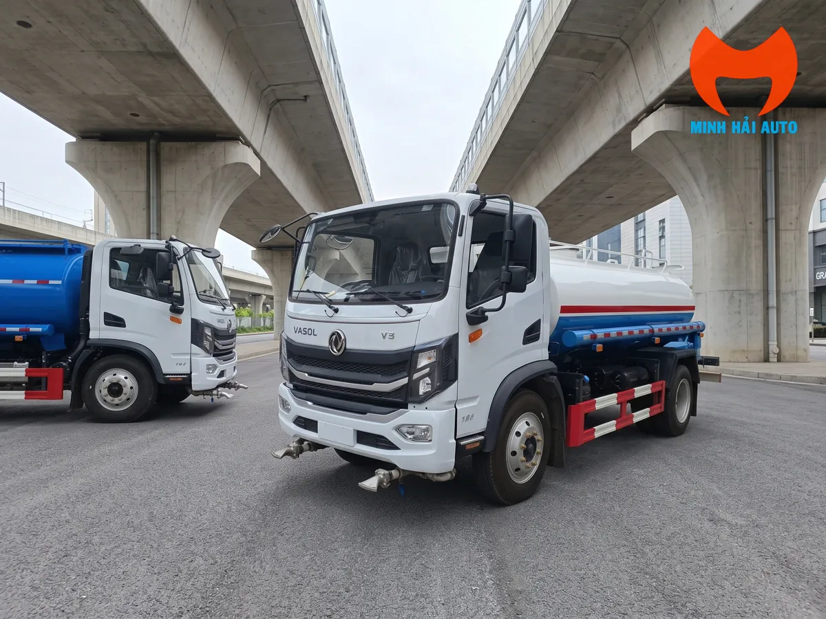 Xe phun nước bồn trắng xanh nhìn từ góc trước tại khu vực dưới cầu cạn