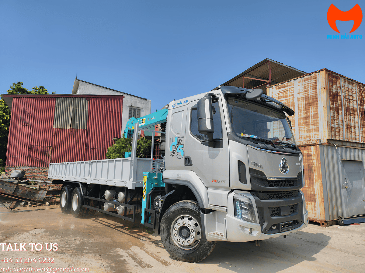 Xe tải Chenglong H5 3 chân gắn cẩu HLC 5 tấn 4 đốt đang vươn cần tại công trình xây dựng.