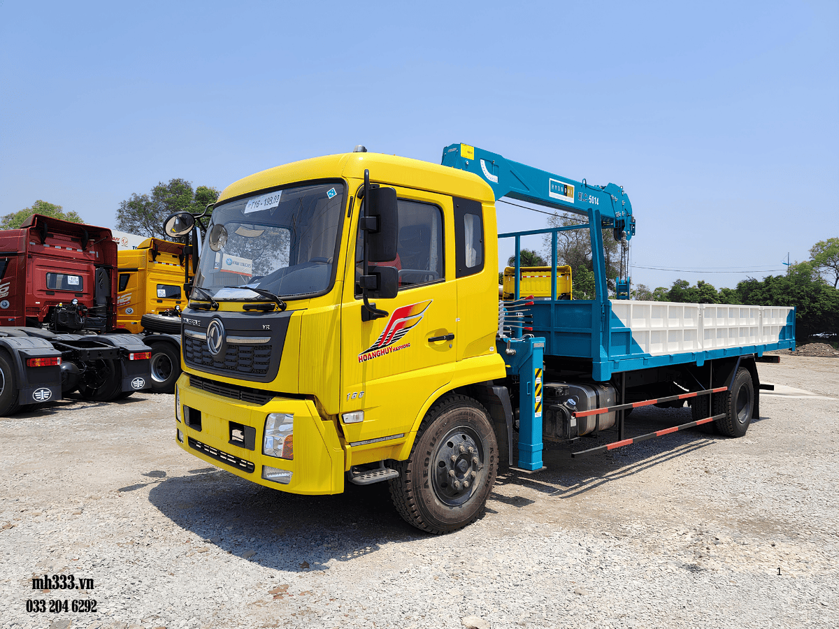Xe tải dongfeng hoàng huy gắn cẩu 5 tấn đang làm việc tại một công trình xây dựng.