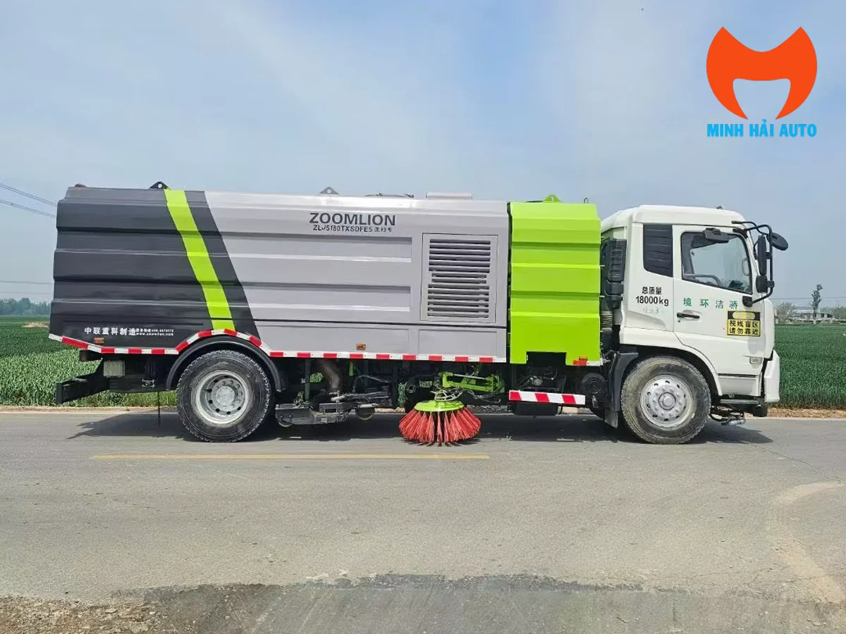 Xe quét đường Zoomlion nhìn ngang với chổi quét bên hông và thân xe xám xanh