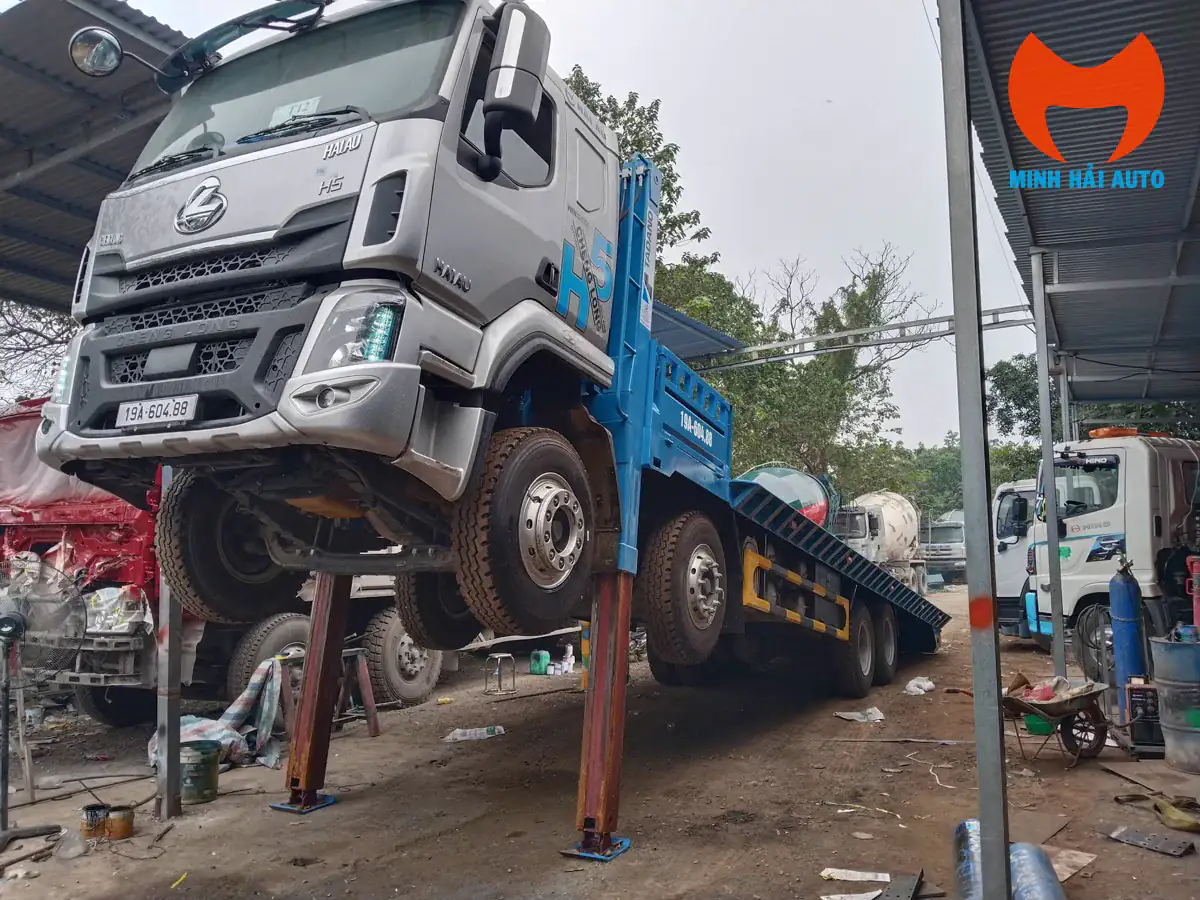 Xe Chenglong H5 cabin bạc, sàn xanh và chân chống đang nâng phía trước xe