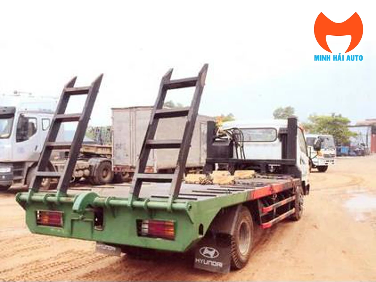 Hyundai HD700 chở máy nhìn từ phía sau với sàn và hai cầu dẫn dựng gập