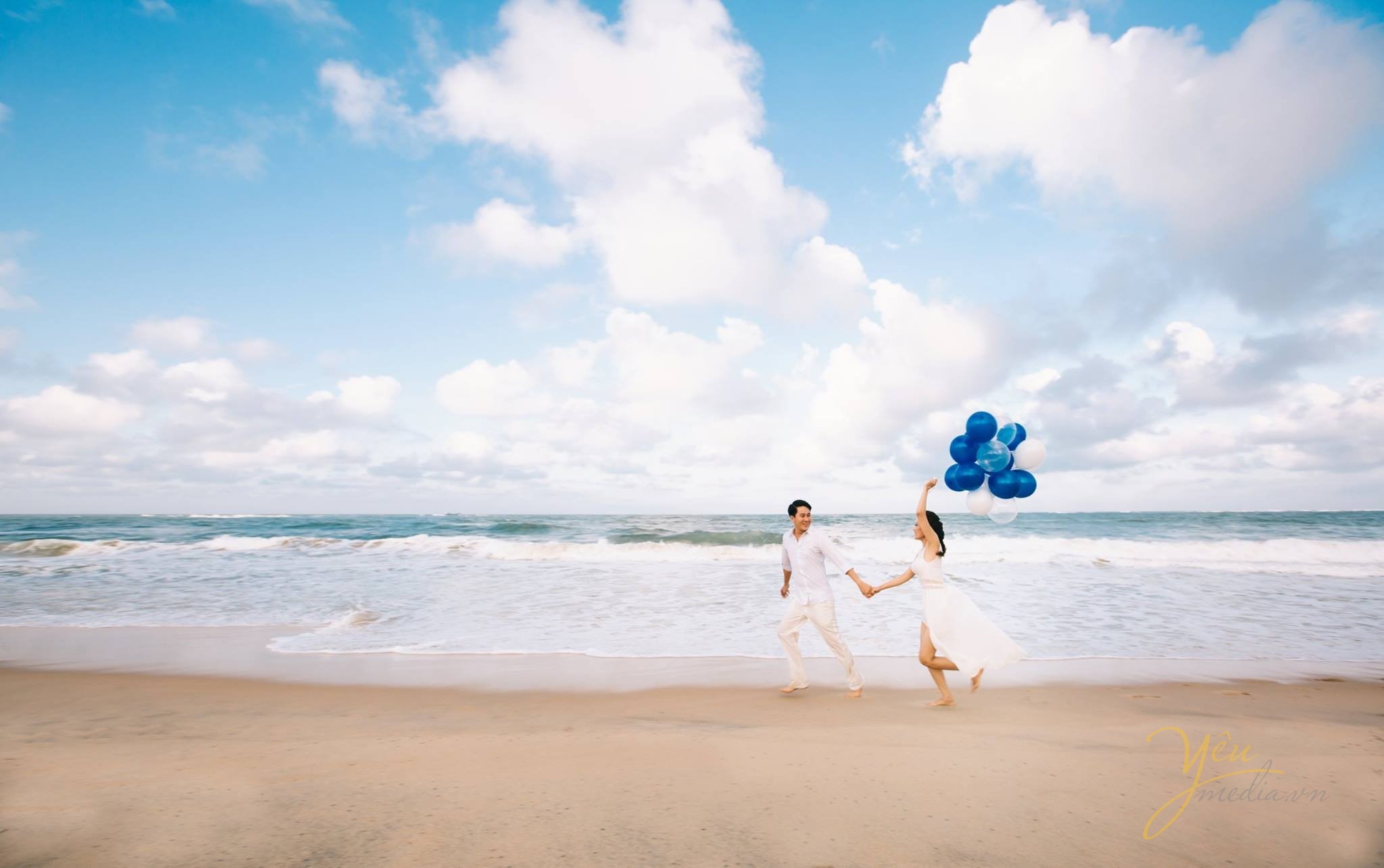 chụp ảnh cưới tại biển cùng bóng bay co dâu chú rể dắt tay nhau chạy trên bờ biển