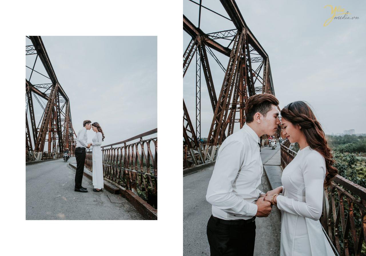 ảnh cưới áo dài trắng chú rể hôn trán cô dâu trên cầu long biên