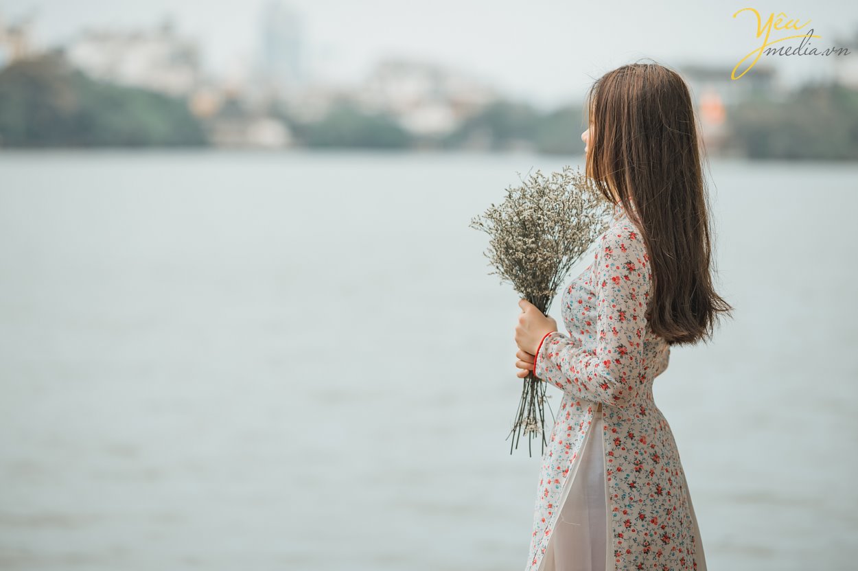 Taking photos of Vietnamese Ao Dai is a trend that many tourists love. To choose a professional, enthusiastic, and passionate photography studio, customers from all over the world, such as Korea, China, Japan, Europe, etc., have chosen Yeumedia studio.  Coming to Yeumedia, you will be consulted enthusiastically, to make the right decision for your impressive photos. Where to take photos, at what time of day, how to choose the context, how to makeup, how to choose the dress, how to make hairdo ... will all be helped by Yeumedia's team to create the set the most beautiful pictures for you in Hanoi.   In Hanoi there are many places suitable for taking traditional costume "Áo Dài" photos for you to choose, for example: Long Bien bridge, the Old Quarter, the Temple of Literature, Dong Xuan market, Sword Lake, etc.   Let's take a look at one sample we made for a Chinese Tourist who fell in love with Hanoi and our "Ao Dai": Ms. Xu Dong Dong