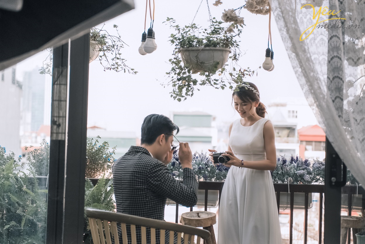 cô gái chụp ảnh cho chàng trai đang bỏ kính