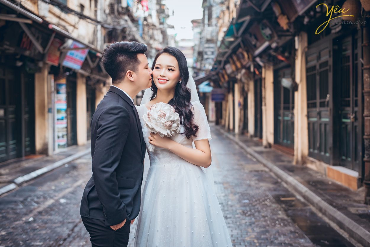 Nếu như ảnh cưới phong cách hiện đại chỉ tập trung chú trọng vào những bức hình lung linh nhiều màu sắc rực rỡ sống động thì ảnh cưới phong cách cổ điển sẽ mang đến cho bạn những gam màu sắc nhẹ nhàng, đơn giản và vô cùng lãng mạn theo sự hoài cổ.  Trong những năm gần đây, xu hướng chụp ảnh cưới phong cách cô điển đang trở lại giống như một làn gió mới thổi đến làm mới những trang ảnh cưới vốn dễ bị trùng lặp về mặt ý tưởng. Chính vì thế đã thu hút được rất nhiều cặp đôi lựa chọn chụp theo phong cách này để mang đến sự độc đáo mới lạ cho mình.   Địa điểm chụp ảnh cưới rất quan trọng vì nó làm nên phong cách chụp ảnh cưới cổ điển độc đáo và lạ mắt này. Đối với phong cách này bạn có thể tìm đến Cung đình cổ của huế, những ngôi nhà cổ, phố cổ, những nơi mang đậm phong cách của Việt Nam cổ xưa, nhẹ nhàng và lãng mạn. Những địa điểm này sẽ giúp bạn lột tả được hết những vẻ đẹp độc đáo riêng của phong cách chụp ảnh cưới này.  Yêu Media xin giới thiệu bộ album ảnh cưới mà cặp đôi Lai - Chinh đã lựa chọn sau khi nhận được sự tư vấn tận tình của các chuyên viên: sự kết hợp giữa phố cổ Tạ Hiền và studio nhẹ nhàng theo style Hàn Quốc - vừa cổ điển và sang trọng tự nhiên theo hơi hướm hiện đại của năm 2019. 