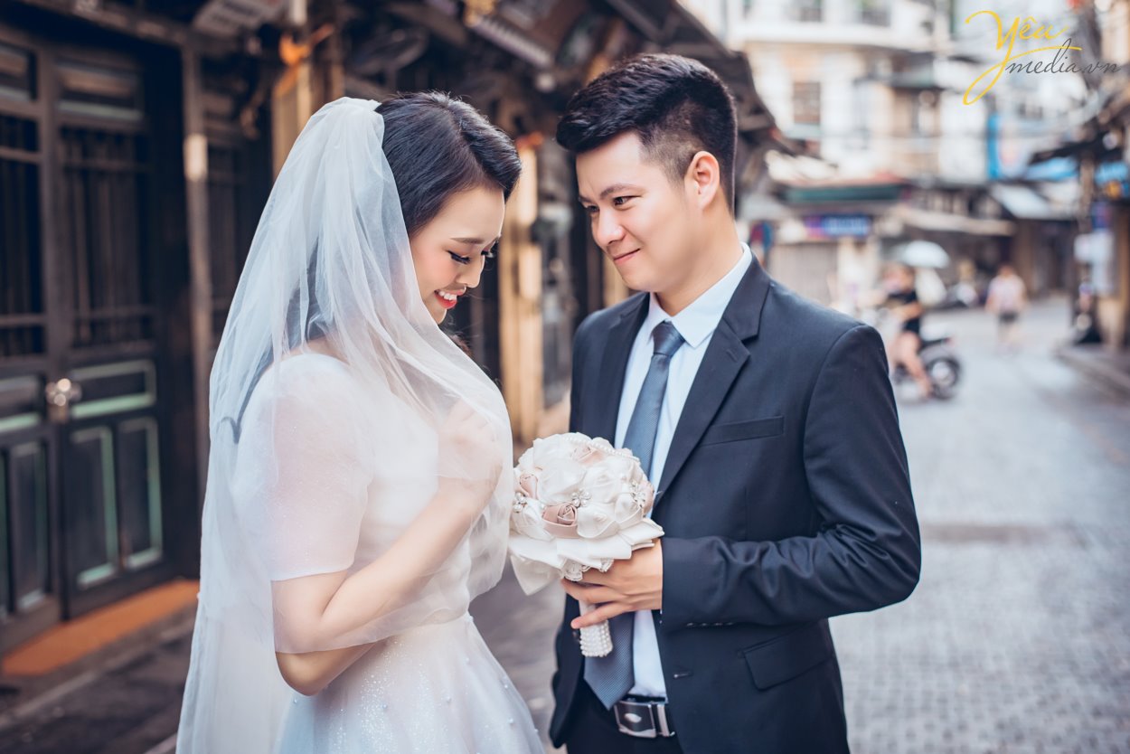 Nếu như ảnh cưới phong cách hiện đại chỉ tập trung chú trọng vào những bức hình lung linh nhiều màu sắc rực rỡ sống động thì ảnh cưới phong cách cổ điển sẽ mang đến cho bạn những gam màu sắc nhẹ nhàng, đơn giản và vô cùng lãng mạn theo sự hoài cổ.  Trong những năm gần đây, xu hướng chụp ảnh cưới phong cách cô điển đang trở lại giống như một làn gió mới thổi đến làm mới những trang ảnh cưới vốn dễ bị trùng lặp về mặt ý tưởng. Chính vì thế đã thu hút được rất nhiều cặp đôi lựa chọn chụp theo phong cách này để mang đến sự độc đáo mới lạ cho mình.   Địa điểm chụp ảnh cưới rất quan trọng vì nó làm nên phong cách chụp ảnh cưới cổ điển độc đáo và lạ mắt này. Đối với phong cách này bạn có thể tìm đến Cung đình cổ của huế, những ngôi nhà cổ, phố cổ, những nơi mang đậm phong cách của Việt Nam cổ xưa, nhẹ nhàng và lãng mạn. Những địa điểm này sẽ giúp bạn lột tả được hết những vẻ đẹp độc đáo riêng của phong cách chụp ảnh cưới này.  Yêu Media xin giới thiệu bộ album ảnh cưới mà cặp đôi Lai - Chinh đã lựa chọn sau khi nhận được sự tư vấn tận tình của các chuyên viên: sự kết hợp giữa phố cổ Tạ Hiền và studio nhẹ nhàng theo style Hàn Quốc - vừa cổ điển và sang trọng tự nhiên theo hơi hướm hiện đại của năm 2019. 
