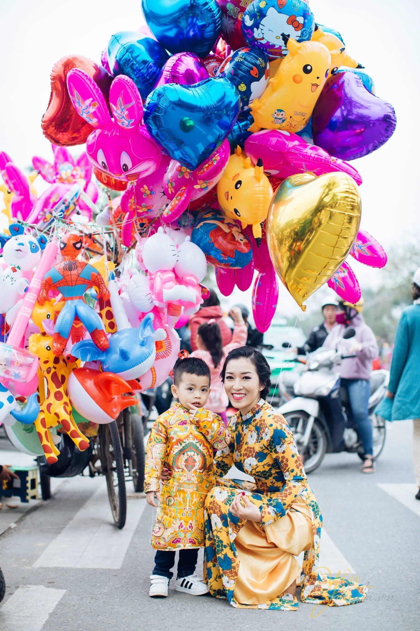 mẹ và bé mặc áo dài chụp ảnh tết với bóng bay màu sắc