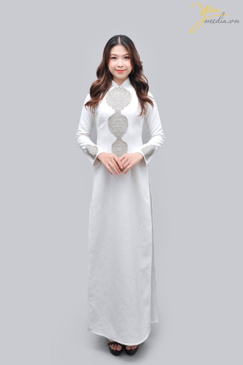 Áo dài gấm trắng mã số 58 vừa đơn giản, lại dễ phù hợp với các dịp khác nhau/ Các cô dâu của Yêu Media thường xuyên chọn mẫu áo dài này để chụp ảnh vì tính nhẹ nhàng và sang trọng của nó. Đi kèm áo bạn sẽ được lựa chọn màu quần áo dài ưa thích như đen, trắng... 