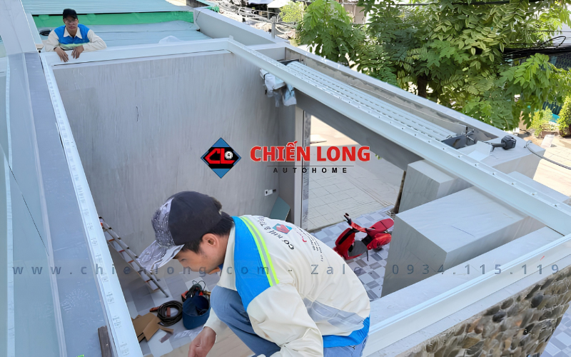 Kỹ thuật viên lắp đặt khung mái nhôm xếp lật trên ô mái