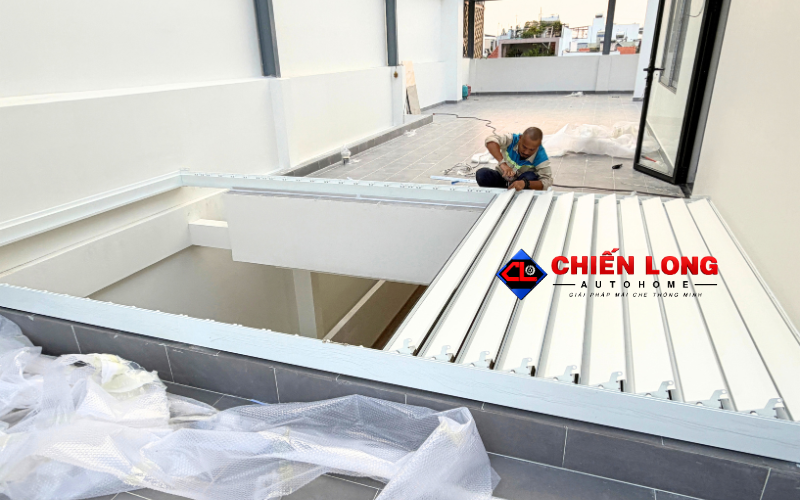 Mái nhôm xếp lật tự động che ban công với không gian sinh hoạt bên dưới.