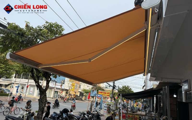 Mái hiên vải màu vàng đang mở che mặt tiền cửa hàng