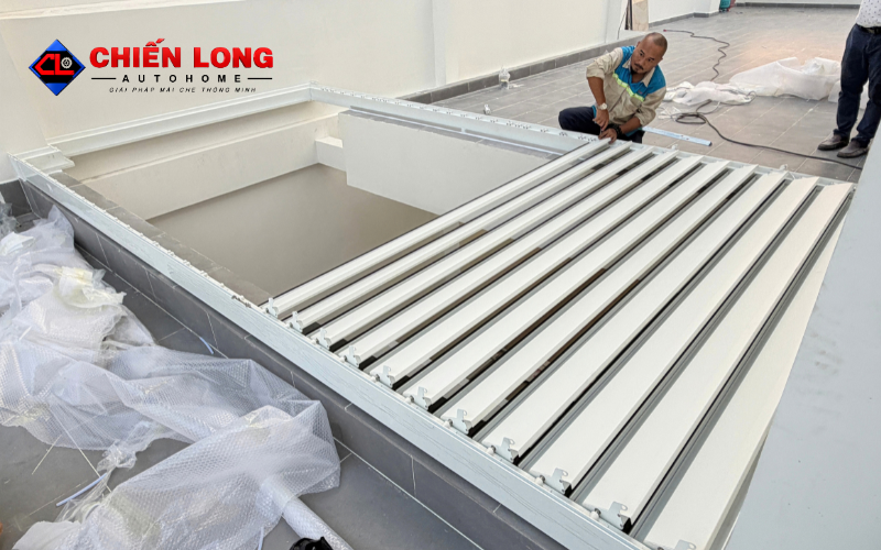 Kỹ thuật viên khảo sát và lắp đặt mái nhôm xếp lật tại ban công.