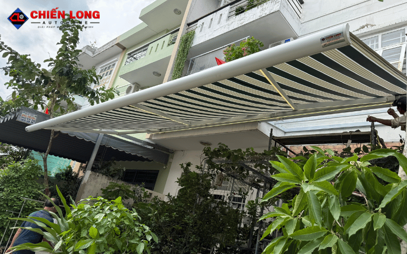 Mái hiên vải sọc đang mở che khoảng sân trước nhà