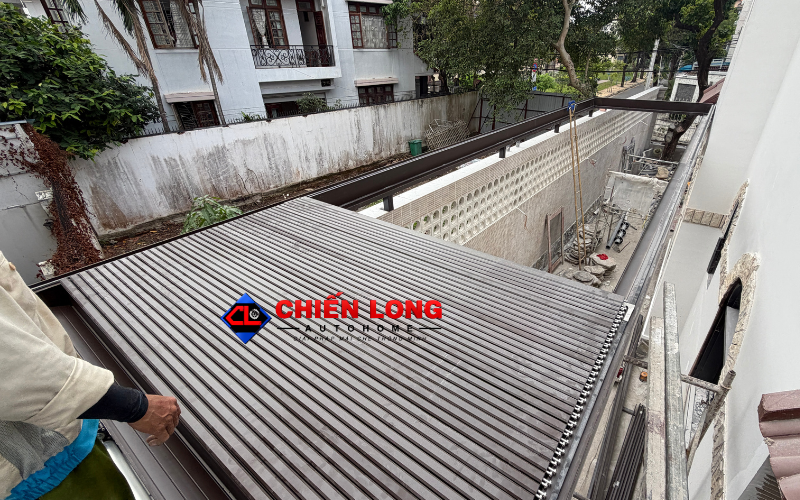 Kỹ thuật viên lắp đặt hệ ray mái nhôm xếp trượt tại sân sau.