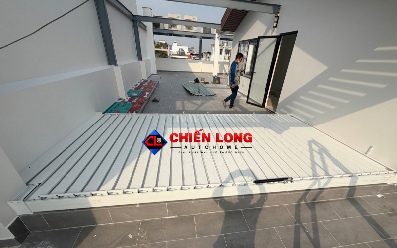 Mái nhôm xếp lật che sân thượng với không gian sinh hoạt bên dưới.