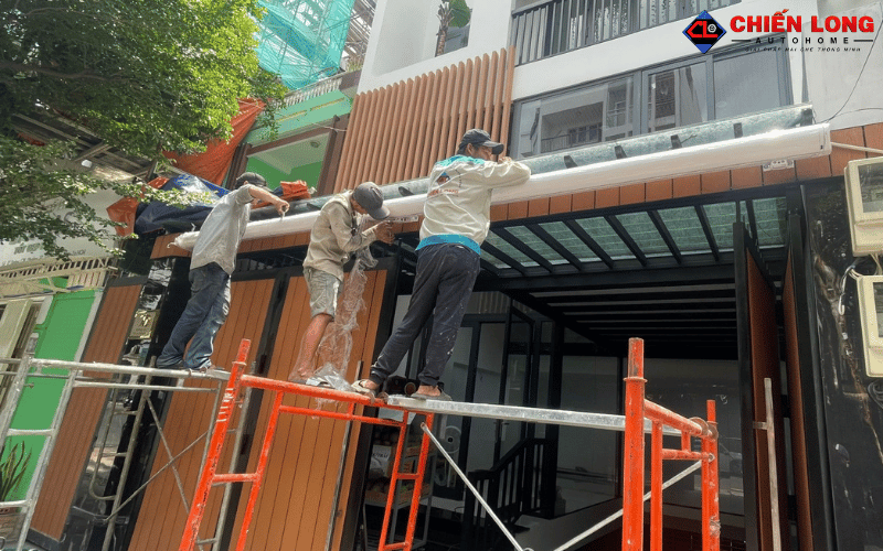 Đội ngũ thi công căn chỉnh bộ mái hiên tự động trên giàn giáo tại Tân Bình