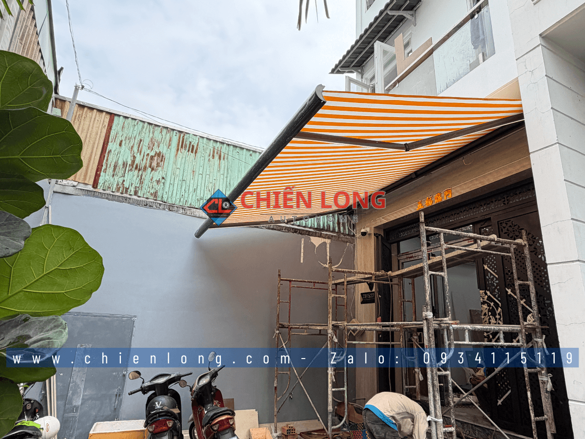 Mái hiên tự động màu cam sọc trắng che nắng nhà phố