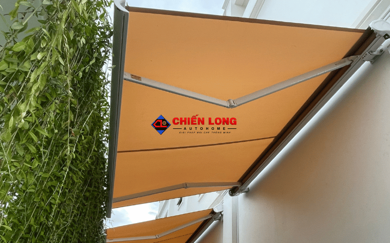 Mái hiên tự động vải vàng với tay đỡ màu bạc tại công trình Long An