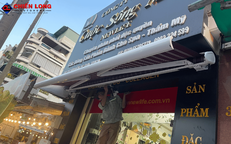 Mái hiên tự động mở một phần dưới bảng hiệu cửa hàng Cuộc Sống Mới tại Quận 10