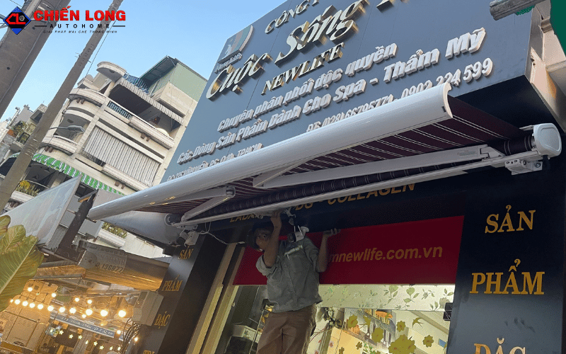 Kỹ thuật viên thao tác dưới mái hiên tự động đang mở một phần tại Quận 10