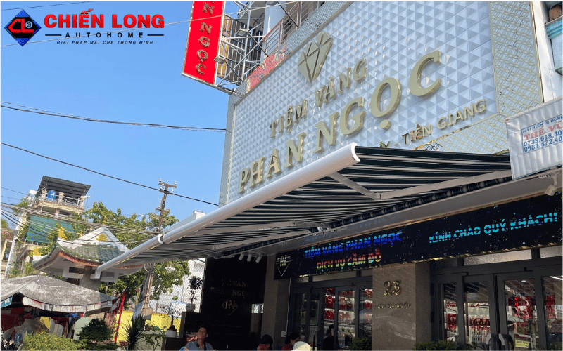 Mái hiên tự động sọc xanh trắng tại tiệm vàng Phan Ngọc, Tiền Giang