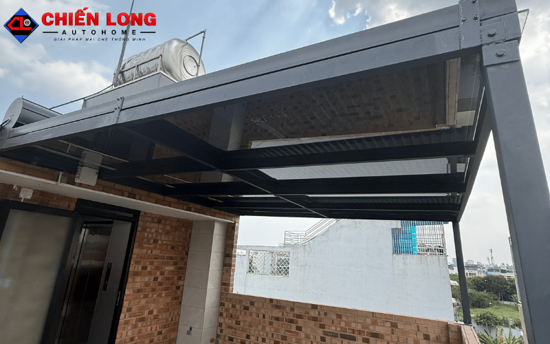 Khung đỡ màu xám của hệ mái kính và mái nhôm cuốn tại Bình Thạnh