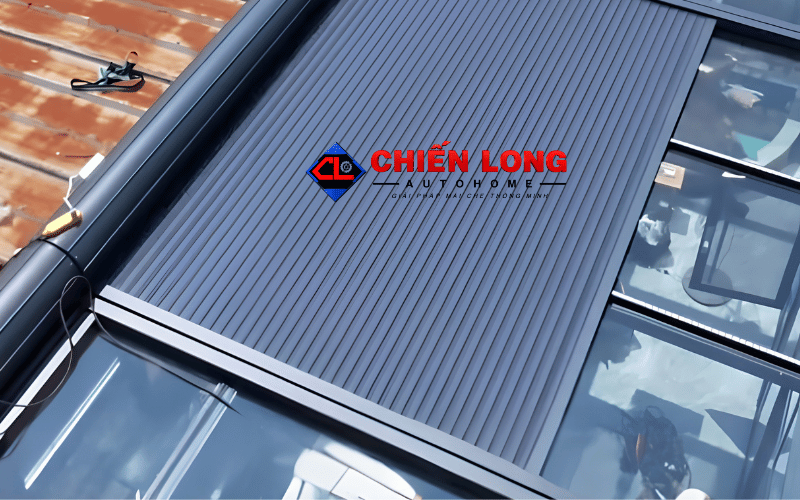 Mái nhôm cuốn tự động Chiến Long màu xám lắp đặt trên mái kính che nắng.