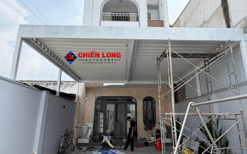 Mái nhôm Ziczac màu trắng che sân trước trong quá trình thi công, nhìn từ cổng vào