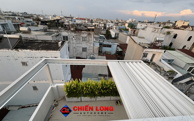 Mái nhôm Ziczac thu về bên phải, mở một phần sân thượng có bồn cây.