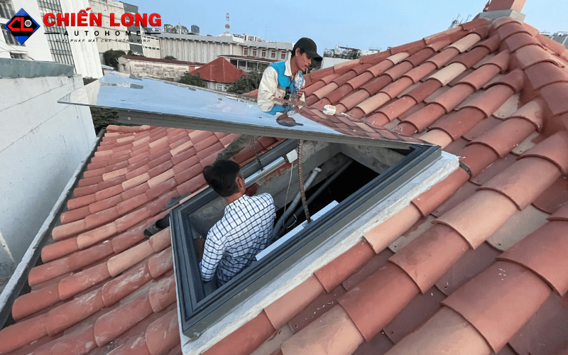 Đội ngũ thi công lắp cánh giếng trời lật úp trên mái ngói đỏ