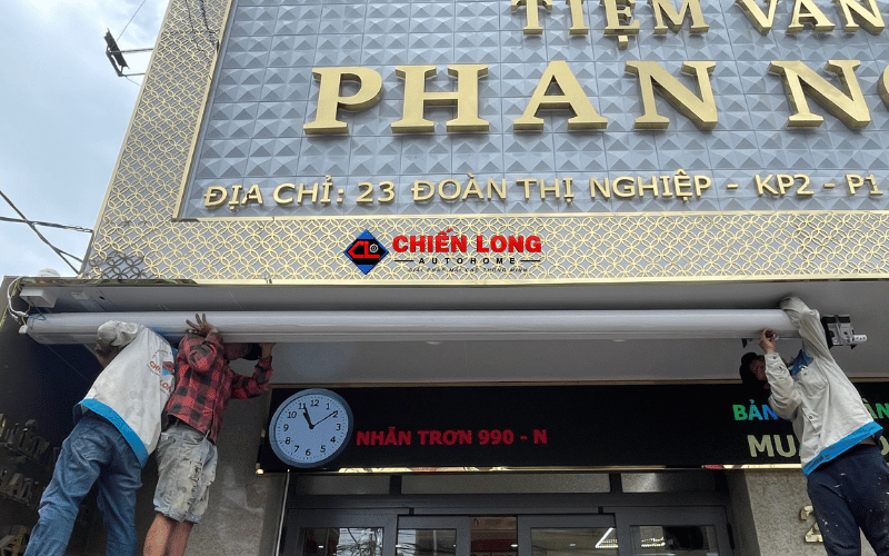 Thợ Chiến Long Autohome lắp hộp mái hiên tự động dưới bảng hiệu tiệm vàng Phan Ngọc