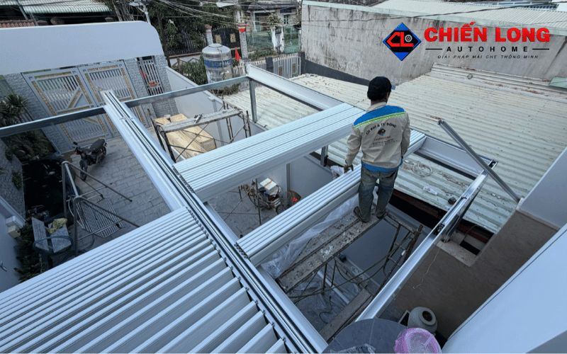 Kỹ thuật viên lắp đặt mái nhôm Ziczac màu trắng tại khu vực sân trước