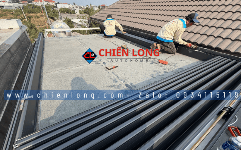 Kỹ thuật viên lắp mái nhôm Ziczac trên mái kính với các lá nhôm đang thu gọn.