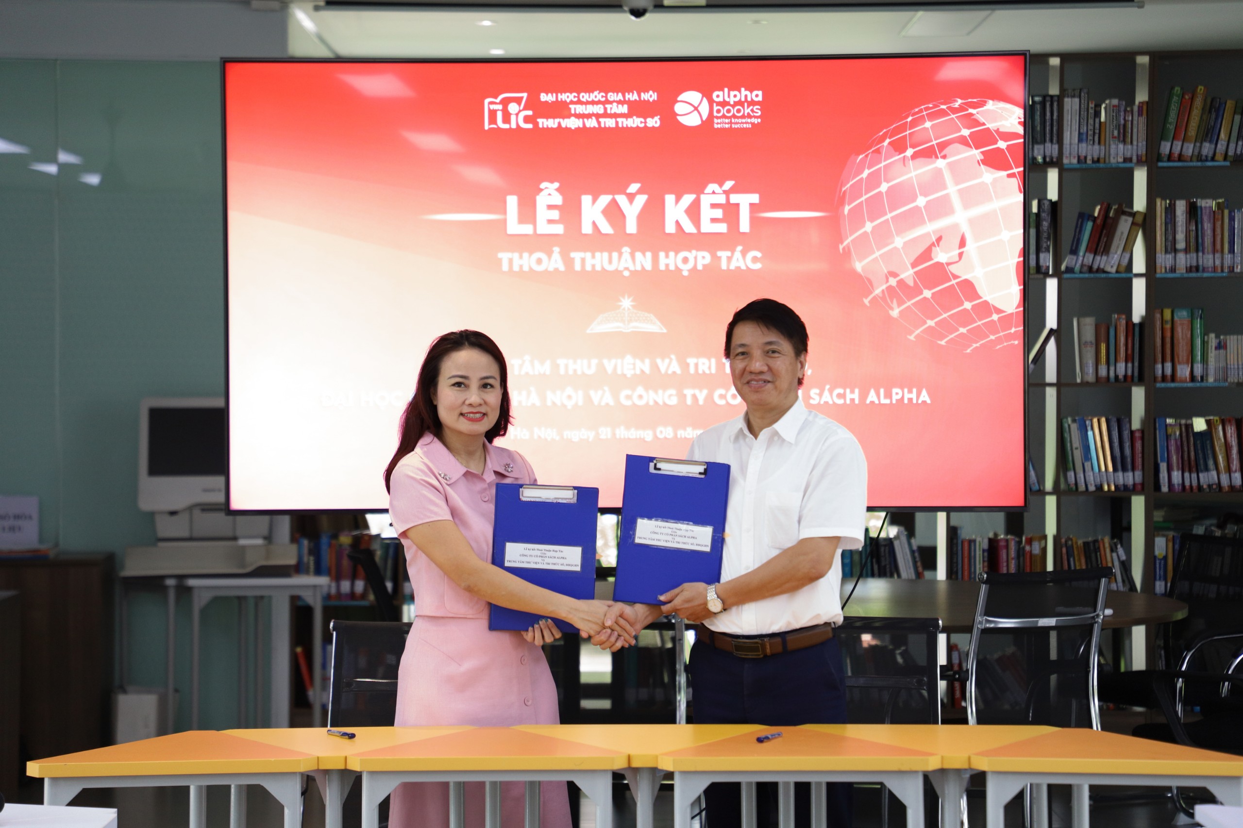 Th.S Hoàng Văn Dưỡng, Phó giám đốc VNU-LIC và bà Tạ Liên Hương, Giám đốc điều hành Alpha Books, bắt tay ký kết thỏa thuận hợp tác