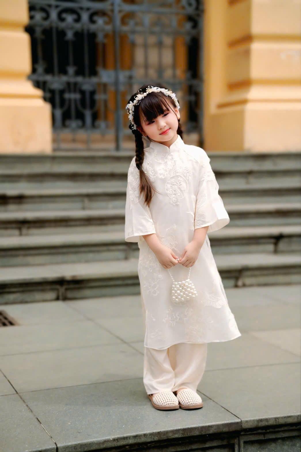 Áo Dài Bé Gái Voan Kem Thêu Kèm Dây Tua Rua