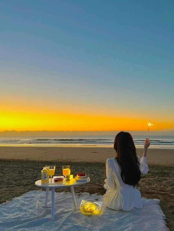 Tạo dáng ngồi bên bãi biển lúc hoàng hôn