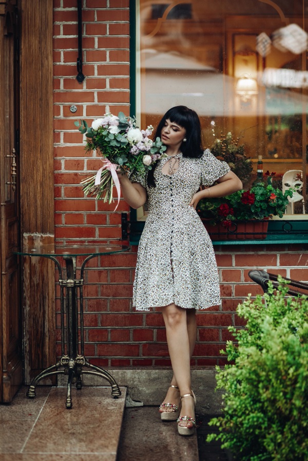 Tạo dáng với bó hoa trước quán cà phê