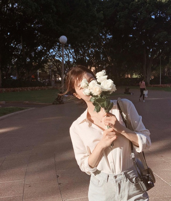 Dùng bó hoa che một phần khuôn mặt