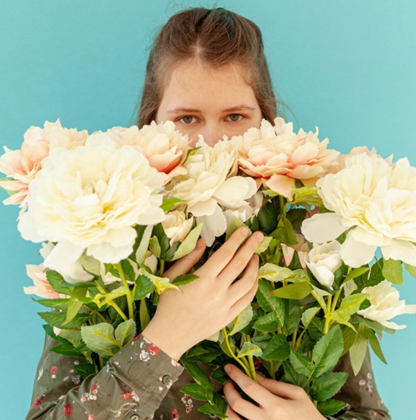 Cầm bó hoa che miệng hoặc che cằm