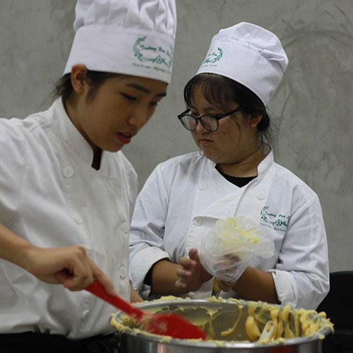 two students cooking pastries