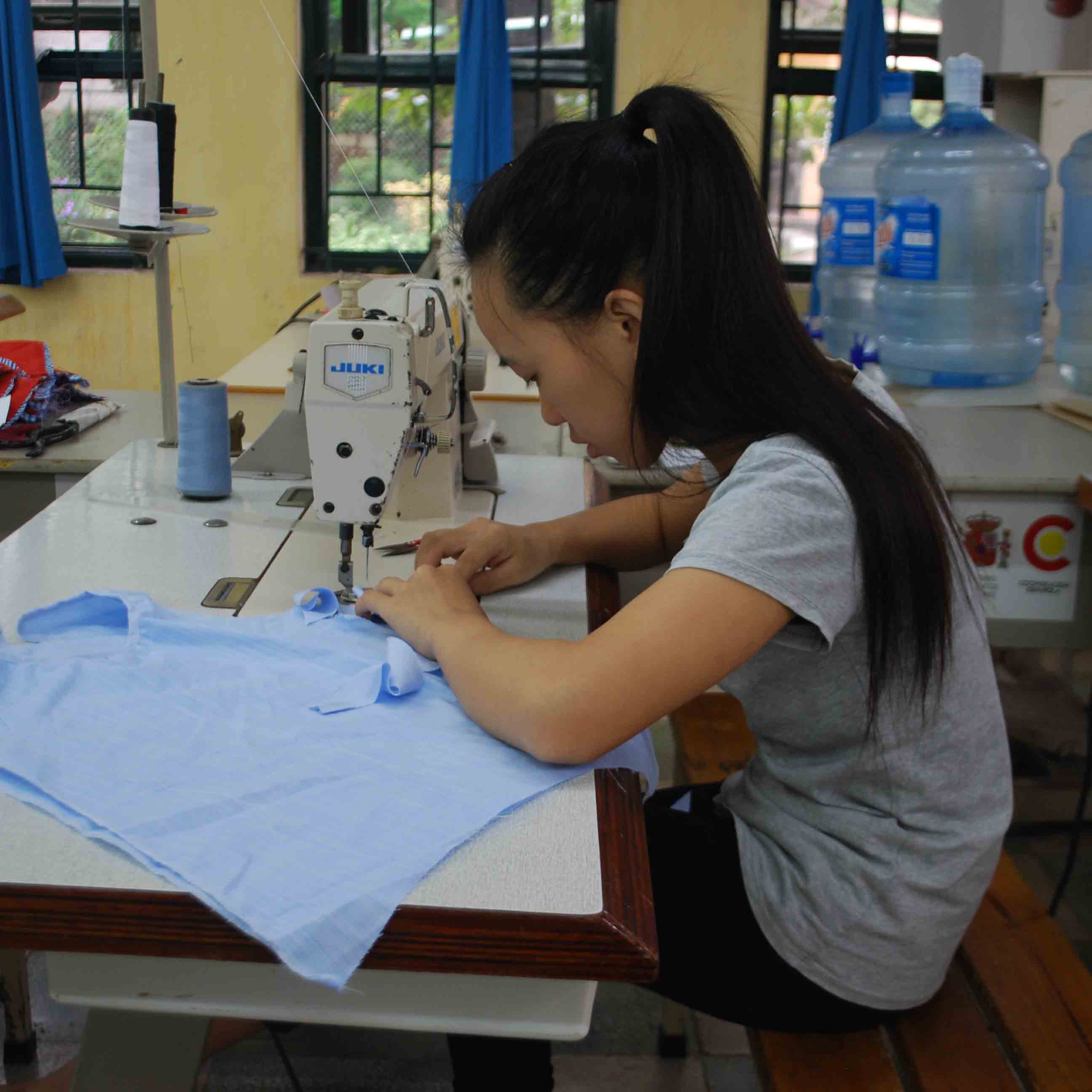 A disabled student sewing at Hoa Sua School