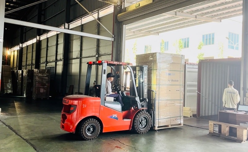Xe nâng dầu 3.5 tấn động cơ Trung Quốc đang đóng hàng vào container tại nhà máy pin mặt trời ở Thái Nguyên