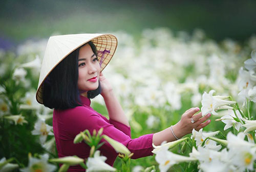 Với áo dài kết hợp hoa loa kèn, bạn sẽ trông như một nàng tiên xinh đẹp. Hình ảnh này sẽ mang lại cho bạn một mối tình đầu Việt Nam thanh thoát và quyến rũ.