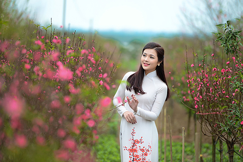 tạo dáng chụp ảnh áo dài trắng với hoa đào xuân 2019