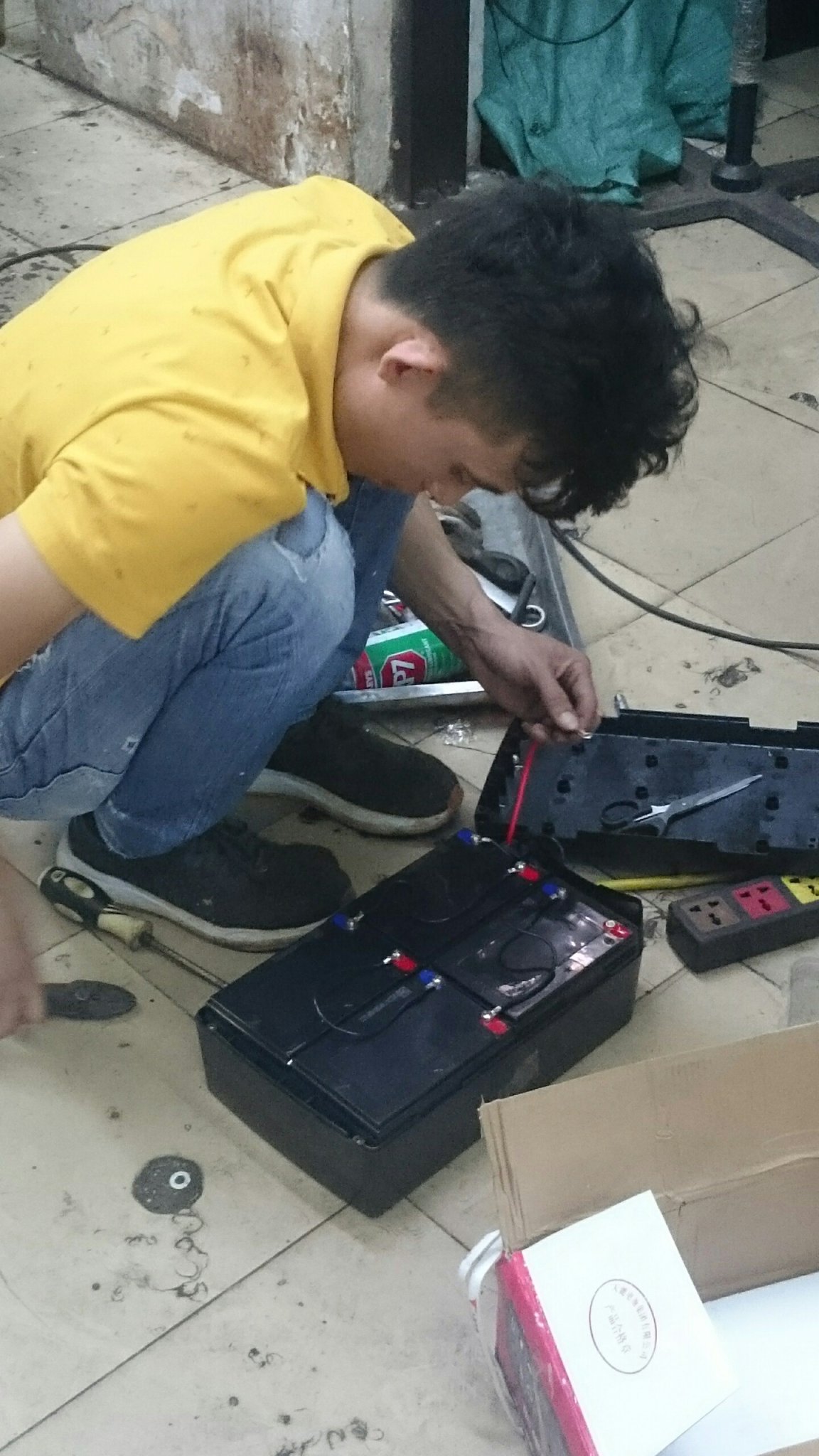 kĩ thuật viên đang thay ắc quy mới cho xe đạp điện tại cửa hàng xe điện Lan Anh