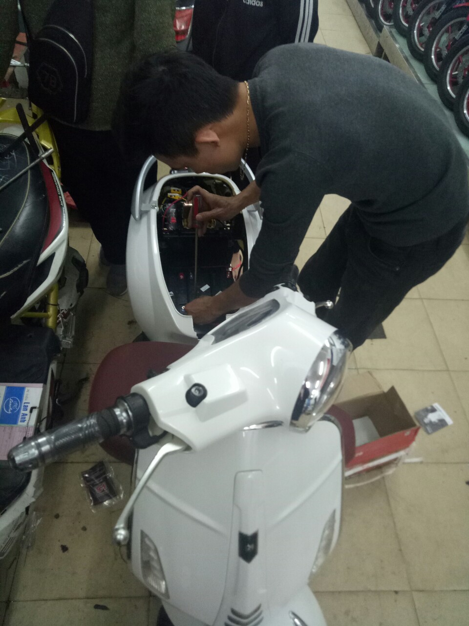 Kĩ thuật đang lắp ắc quy xe máy điện Vespa