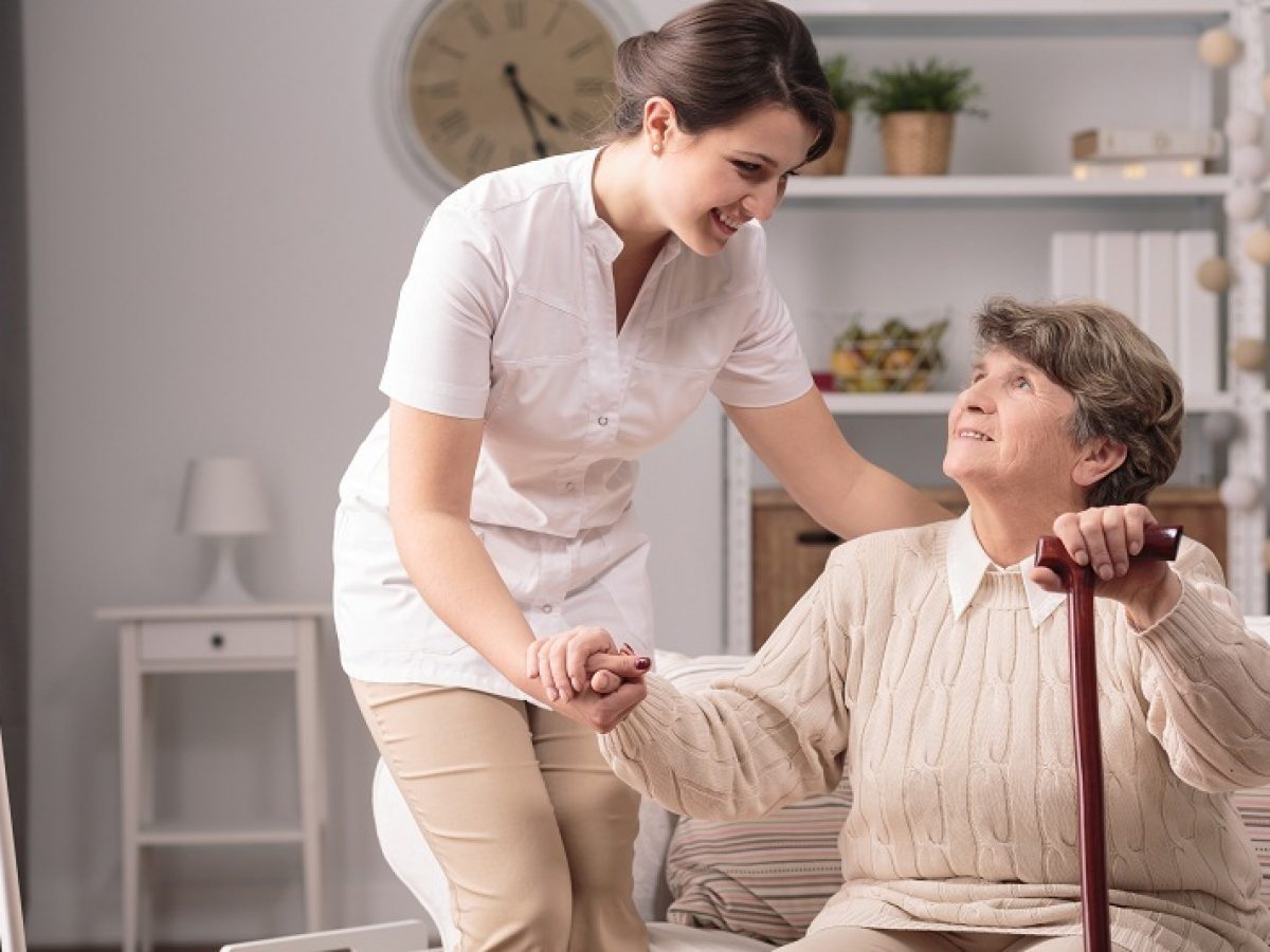 Nhân viên chăm sóc hỗ trợ người cao tuổi đi lại trong nhà